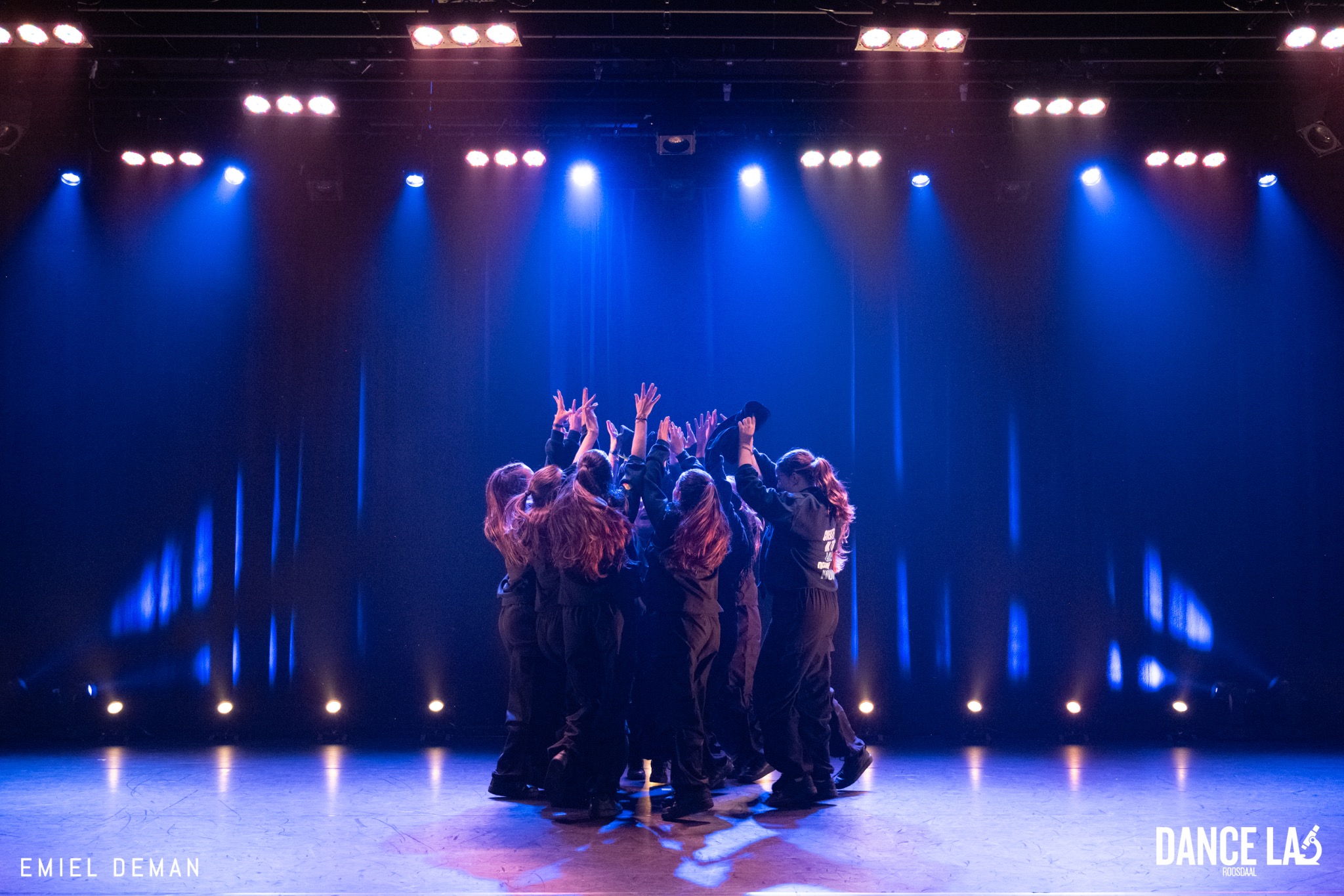 Een Dance Lab-crew samen onder blauw podiumlicht